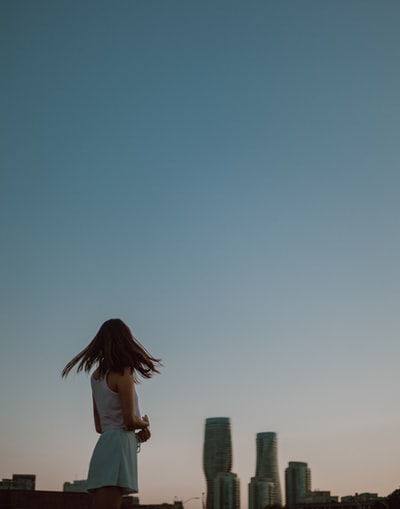 白天，穿着白衬衫的女人站在楼顶上